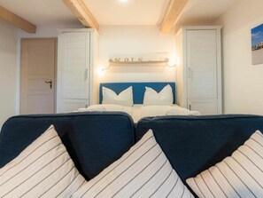 A room with a bed, two bedside tables, a wall-mounted sign, and a door. - Holiday Apartment 5 "grode" (Tating)