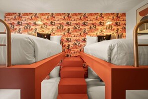 Ein Zimmer mit Etagenbetten, einer Treppe und einer Wand mit Muster.