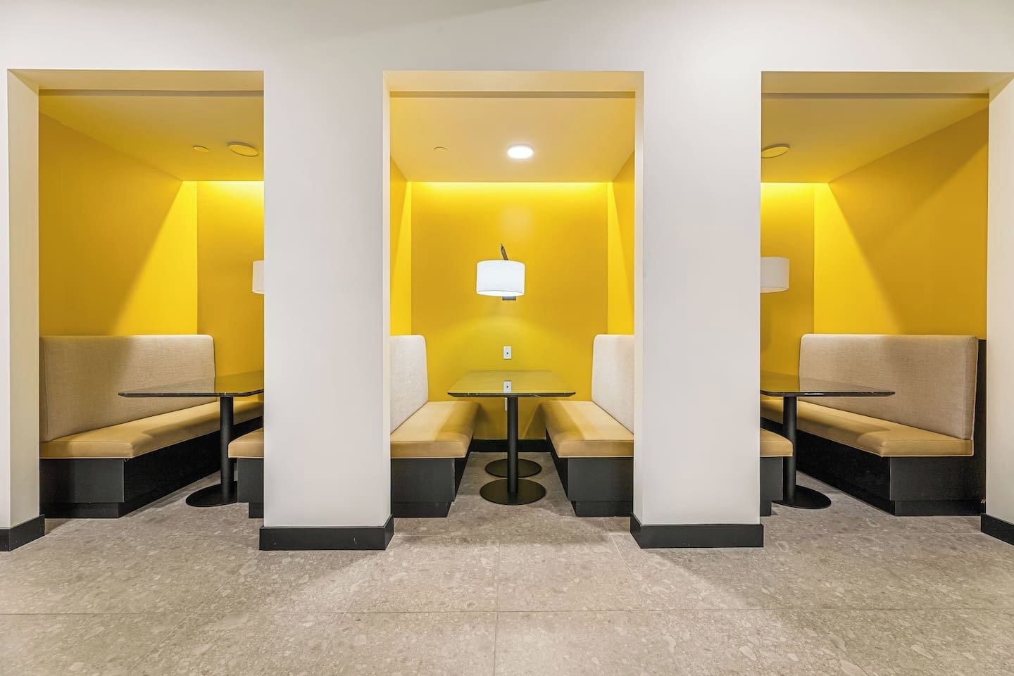 A hotel lobby with a central seating area, a chandelier, and a tiled floor.