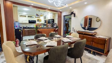 A dining area with a wooden table, chairs, and a mirror on the wall.