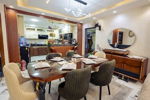 A dining area with a wooden table, chairs, and a mirror on the wall.