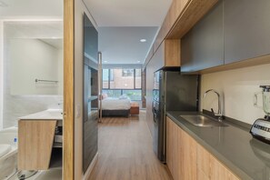 A modern kitchen with a built-in refrigerator, a sink, and a coffee machine. - Apto Moderno 1 hab Bog Sierra Madre (Bogotá)