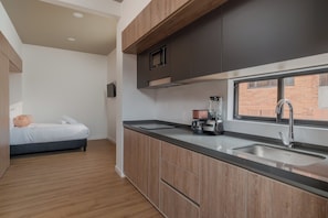 A modern kitchen with a built-in stove, a sink, and a window. - Studio Bogota 1Bed Sierra Madre 306 (Bogotá)