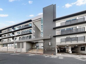A multi-story building with a modern architectural design, featuring a prominent vertical element and a covered entrance. - Unbeatable Convenience, the City on your Doorstep (Fortitude Valley)
