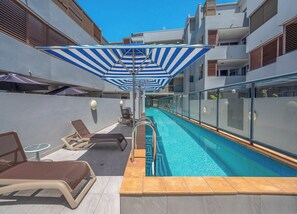 A rooftop pool area with sun loungers, a pool, and a glass railing. - Unbeatable Convenience, the City on your Doorstep (Fortitude Valley)