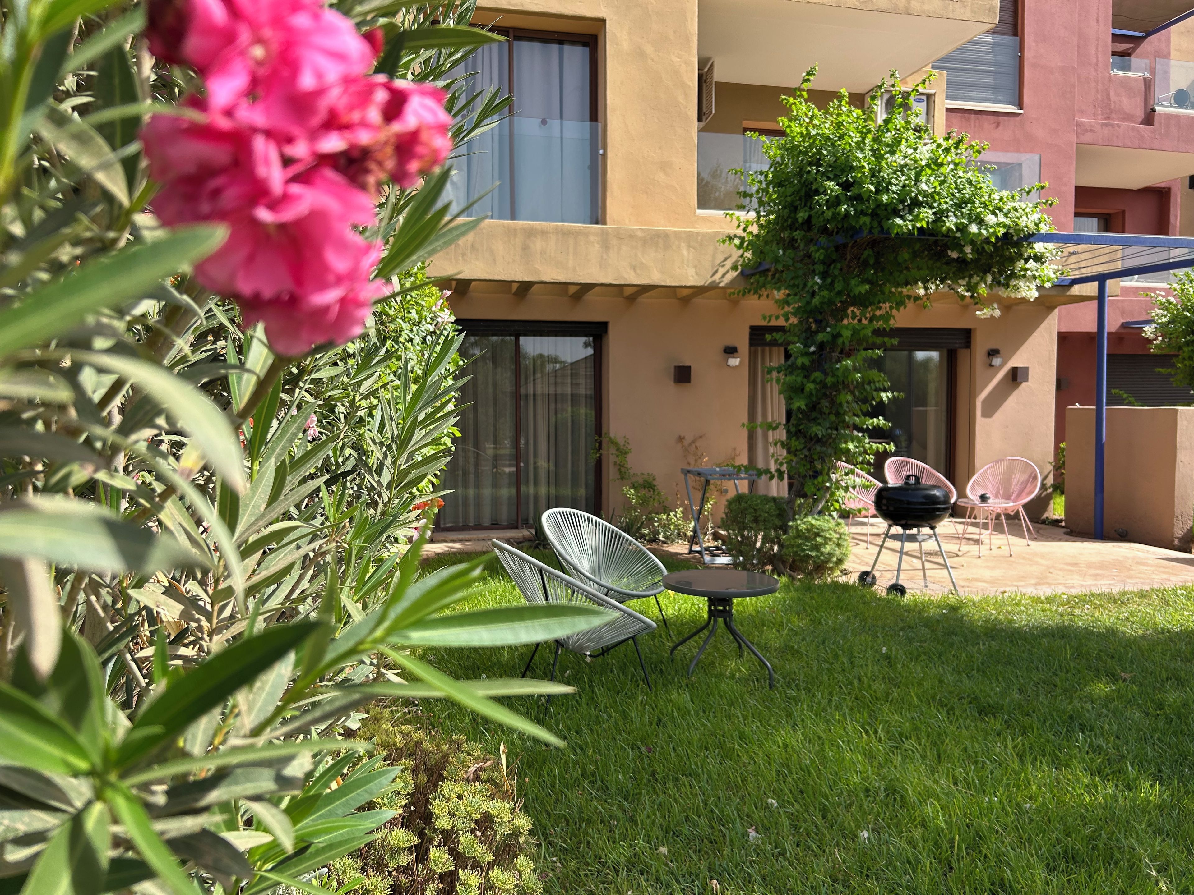 A residential building with a patio area featuring outdoor furniture and a small garden.