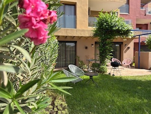 Un edifici residencial amb un pati que té mobiliari exterior i un jardí petit.
