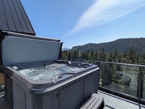 Un bain à remous sur un balcon avec vue sur les montagnes.