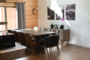 Un coin repas avec une table en bois, des chaises et un petit meuble.