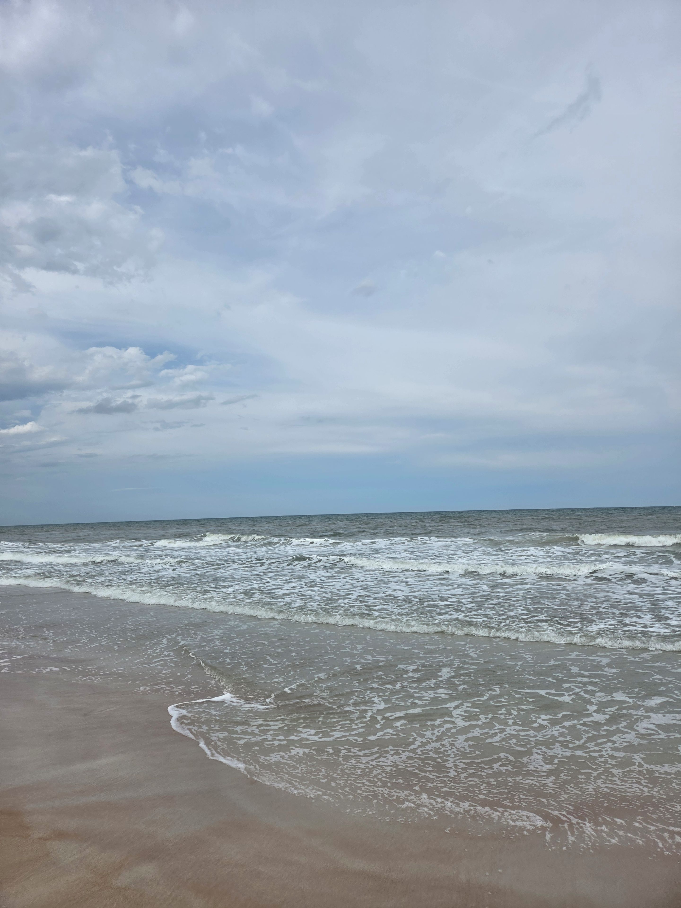 A beach with waves approaching the shore.
