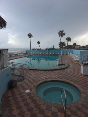 A pool area with a hot tub, lounge chairs, and a view of the ocean. - Oceanfront Paradise at Fountain Beach Resort in gorgeous Daytona Beach (Daytona Beach Shores)