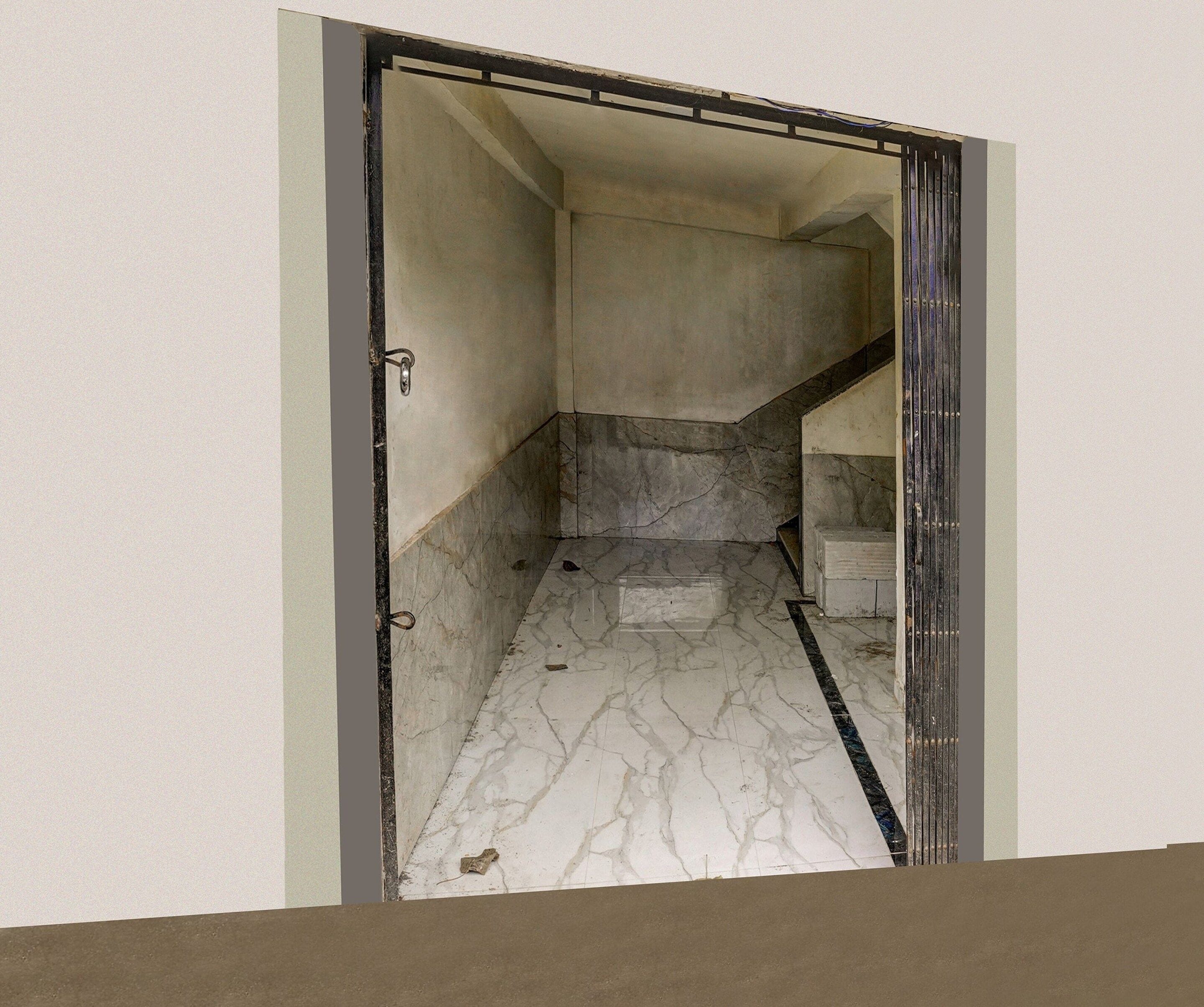 A hallway with a marble floor leading to a staircase.