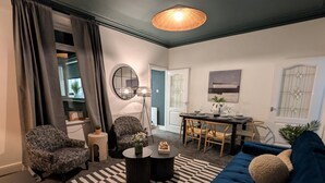 Un salon moderne comprenant un canapé, un fauteuil, une table basse et un coin repas avec une table et des chaises.