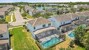 Ett bostadsområde med hus, en swimmingpool och en sjö.
