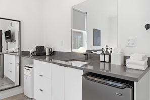 A modern kitchen with a large island, built-in appliances, and a large mirror.