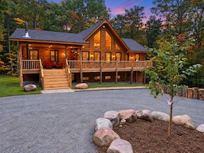 A log cabin with a porch, a covered deck, and a stone pathway leading to the entrance. - Adirondack BearDen - 6BR 4BA Ski/Hike Family Cabin (Jay)