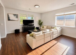 A spacious living room with a sectional sofa, a flat-screen TV, and a coffee table. - Peaceful 3-bedroom house in charming Yelm perfect for relaxing getaway (Yelm)
