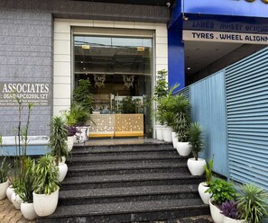 A building entrance with a sign for Associates and a sign for Tyres Wheel Alignment.