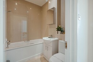 Ein modernes Badezimmer mit einer Badewanne, einem Waschbecken und einer Toilette.