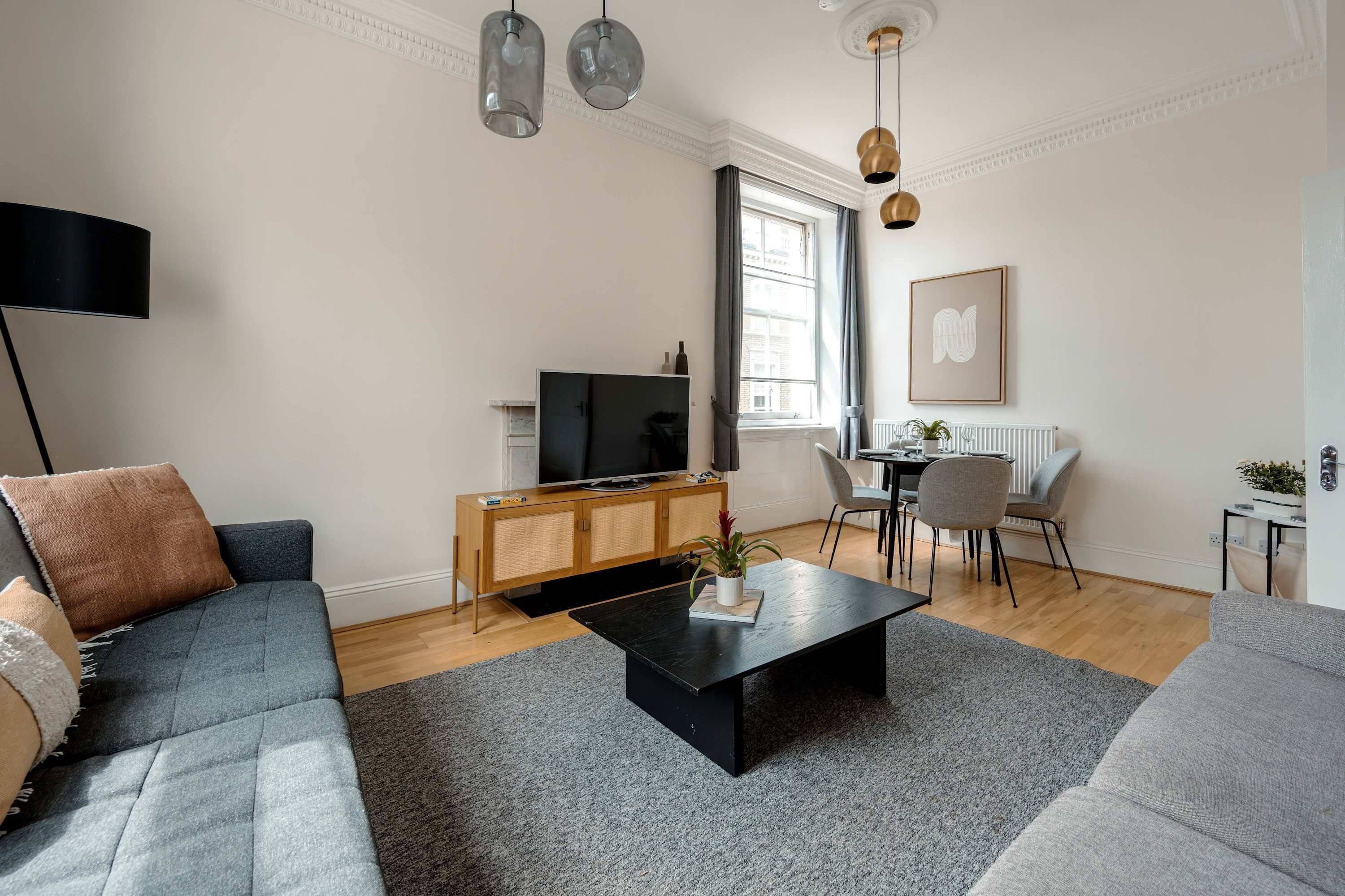 Un salon moderne avec un canapé, une table basse et un téléviseur.
