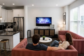 Ein modernes Wohnzimmer mit Fernseher, Sofa und Couchtisch.