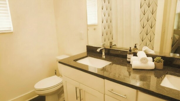 Un baño con inodoro, lavabo, espejo y toalla.