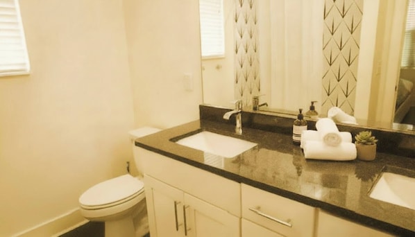 Un baño con inodoro, lavabo, espejo y toalla.