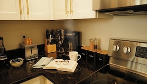 Una cocina equipada con tostadora, cafetera y estufa.
