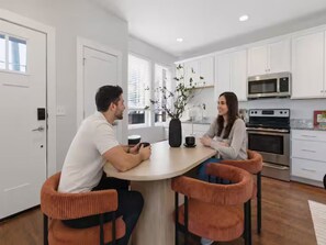 A modern kitchen with white cabinets, stainless steel appliances, and a central island with seating. - Luxury 3BR Retreat | Minutes from Broadway (Nashville)