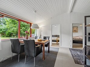 A modern interior with a dining area, a bed, and a view of greenery outside. - "Mea" - 750m from the sea by Interhome (Væggerløse)