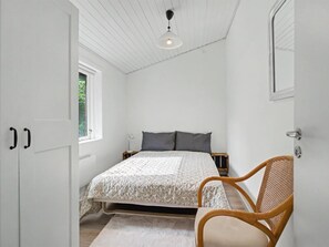 A bedroom with a bed, a chair, a window, and a door. - "Mea" - 750m from the sea by Interhome (Væggerløse)