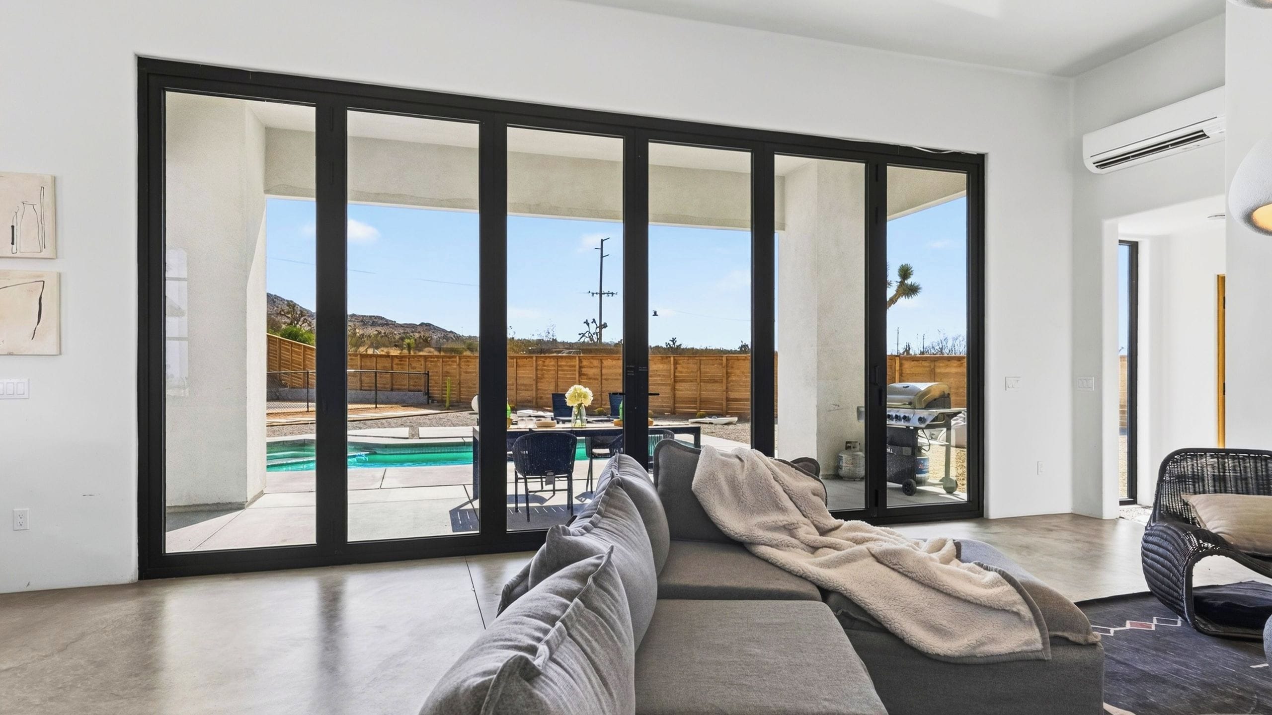 A modern living room with a large sliding glass door leading to an outdoor patio area.