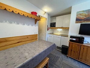 A compact room with a bunk bed, a kitchenette with a microwave, a sink, and a small cabinet with a television. - Séjour montagne - 6 pers avec balcon à Risoul (Risoul)