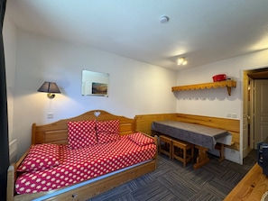 A single bedroom with a bed, a bedside table, a chair, a small desk, a shelf, and a picture on the wall. - Séjour montagne - 6 pers avec balcon à Risoul (Risoul)