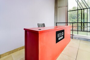 A red reception desk with a sign reading "HOTEL" and "Customer Service." - Super Hotel O Pukkattupady Aluva East (Aluva)