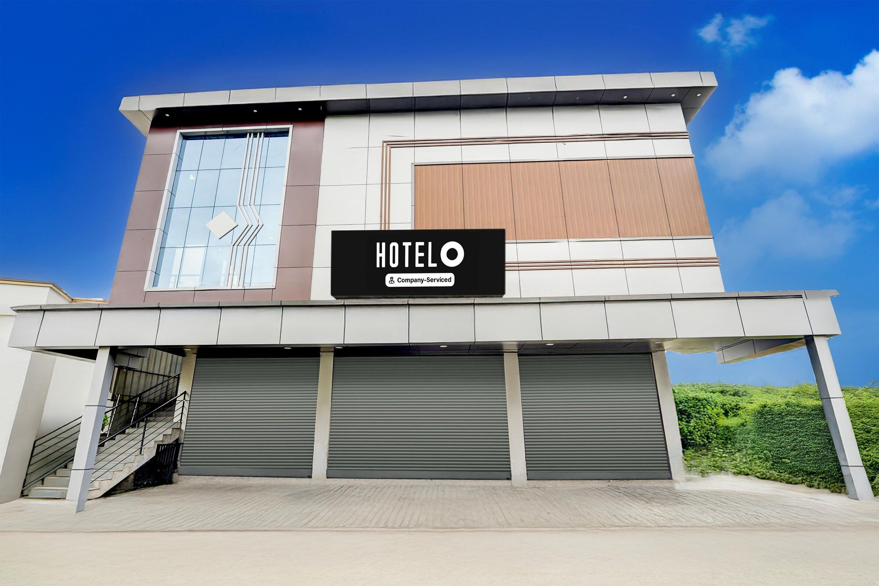 Un hôtel moderne avec une enseigne indiquant « HOTELO Company Serviced ».
