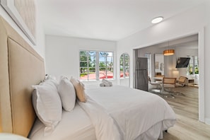 Ein modernes Hotelzimmer mit einem großen Bett, einem Essbereich und Blick ins Freie.