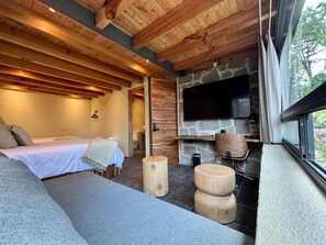 Ein gemütliches Zimmer mit einem Bett, einem Kamin aus Stein und einem großen Fenster.