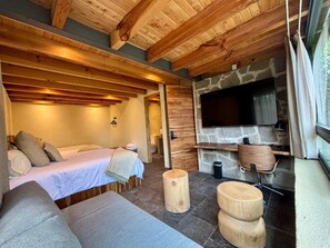 Ein gemütliches Zimmer mit einem Bett, einem Kamin aus Stein und einem Fernseher.
