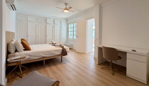 Une chambre à coucher comprenant un lit, une table de chevet, une chaise, un bureau et une armoire.
