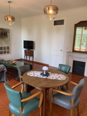A dining area with a round table, chairs, a television, and a fireplace. - G3334 - DRAGUIGNAN - City Break (DRAGUIGNAN)