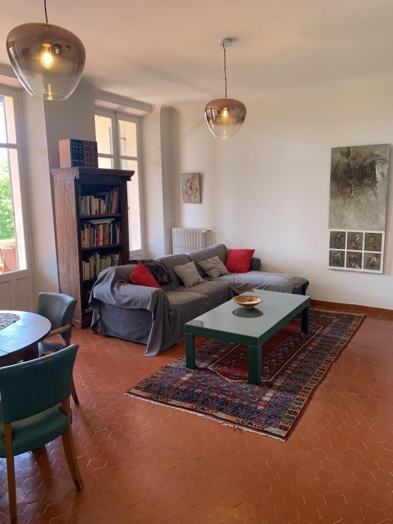 A living room with a sofa, a coffee table, a bookshelf, and a radiator.