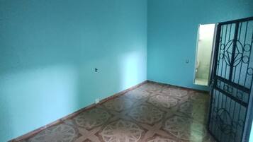 A room with teal walls, a patterned floor, and a metal gate.