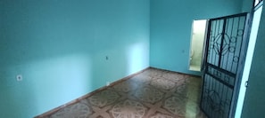 A room with teal walls, a patterned floor, and a metal gate. - Vrbo Property (Manaus)