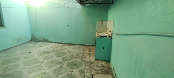 A small, enclosed bathroom with a toilet, a sink, and a tiled floor. - Vrbo Property (Manaus)