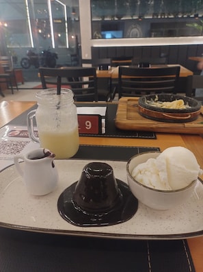 A table with a tray containing a glass of iced tea, a small pitcher of coffee, and a bowl of ice cream. - Vrbo Property (Manaus)