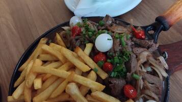 A meal consisting of steak, fries, and bread on a table.