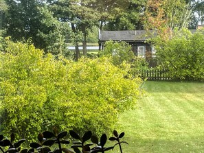 A well-maintained lawn with a wooden fence and a small building in the background. - 5 Person Holiday Home in Rockneby (Rockneby)