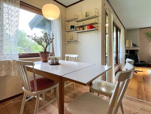 A dining area with a table, chairs, a potted plant, and a hanging light fixture. - 5 Person Holiday Home in Rockneby (Rockneby)