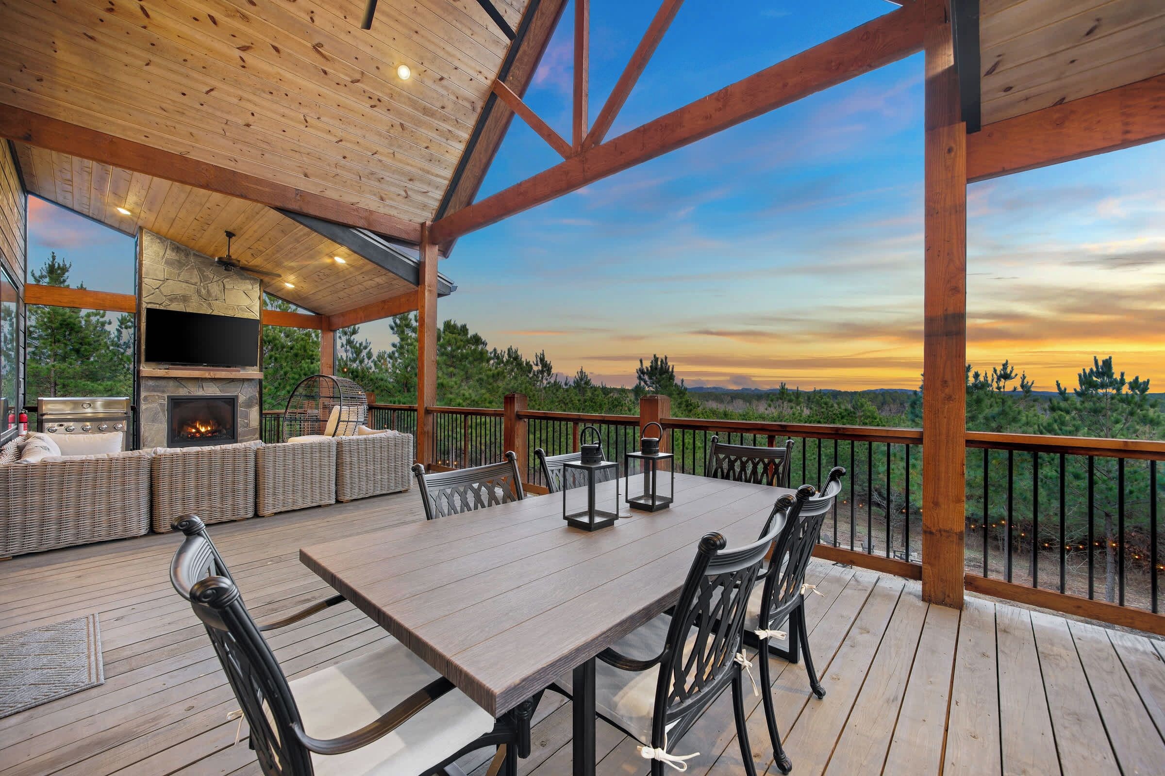 Une terrasse extérieure avec une table à manger, des chaises et une cheminée en pierre.